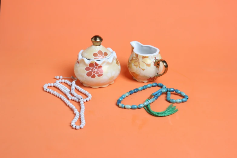 two pieces of porcelain ware on a orange surface