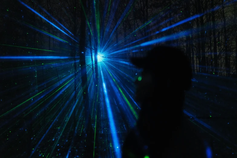 a person standing in the middle of a black room with bright lights on it