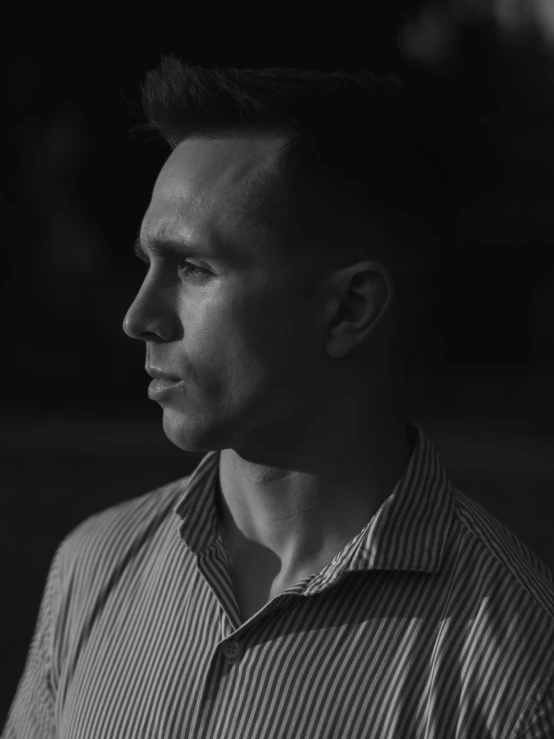 black and white pograph of a man in striped shirt