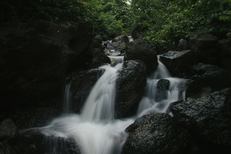 water is coming out of the rocks into a stream