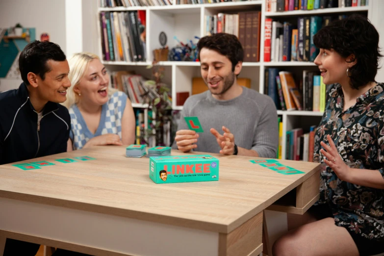 three people laugh as they talk at the same table