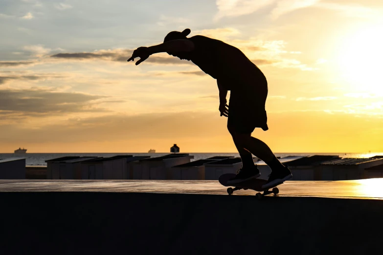 a person with a skateboard near a wall on a beach