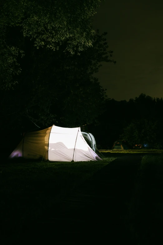 an illuminated tent is outside in the dark