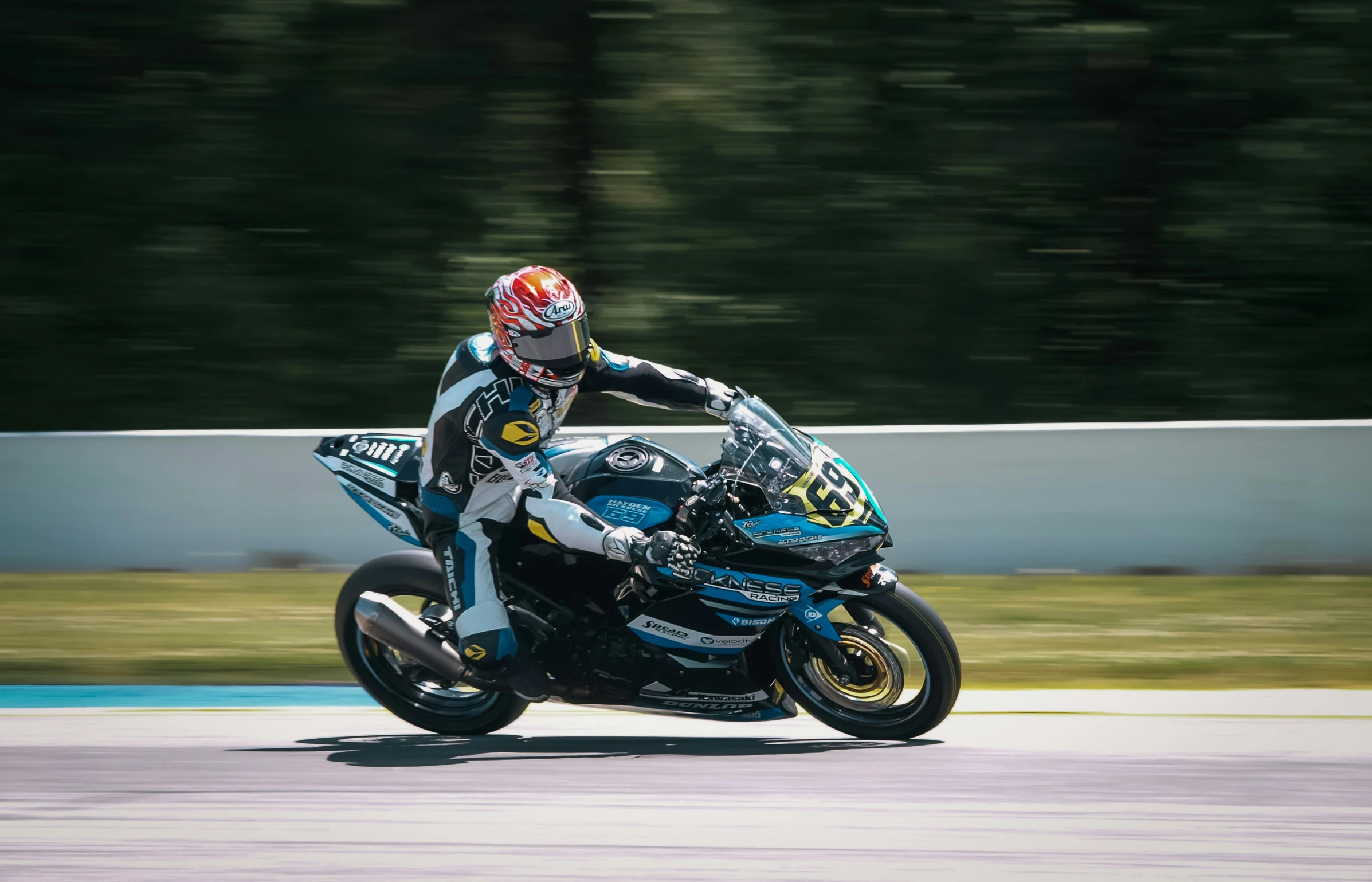 the man in a red helmet is riding his motorcycle