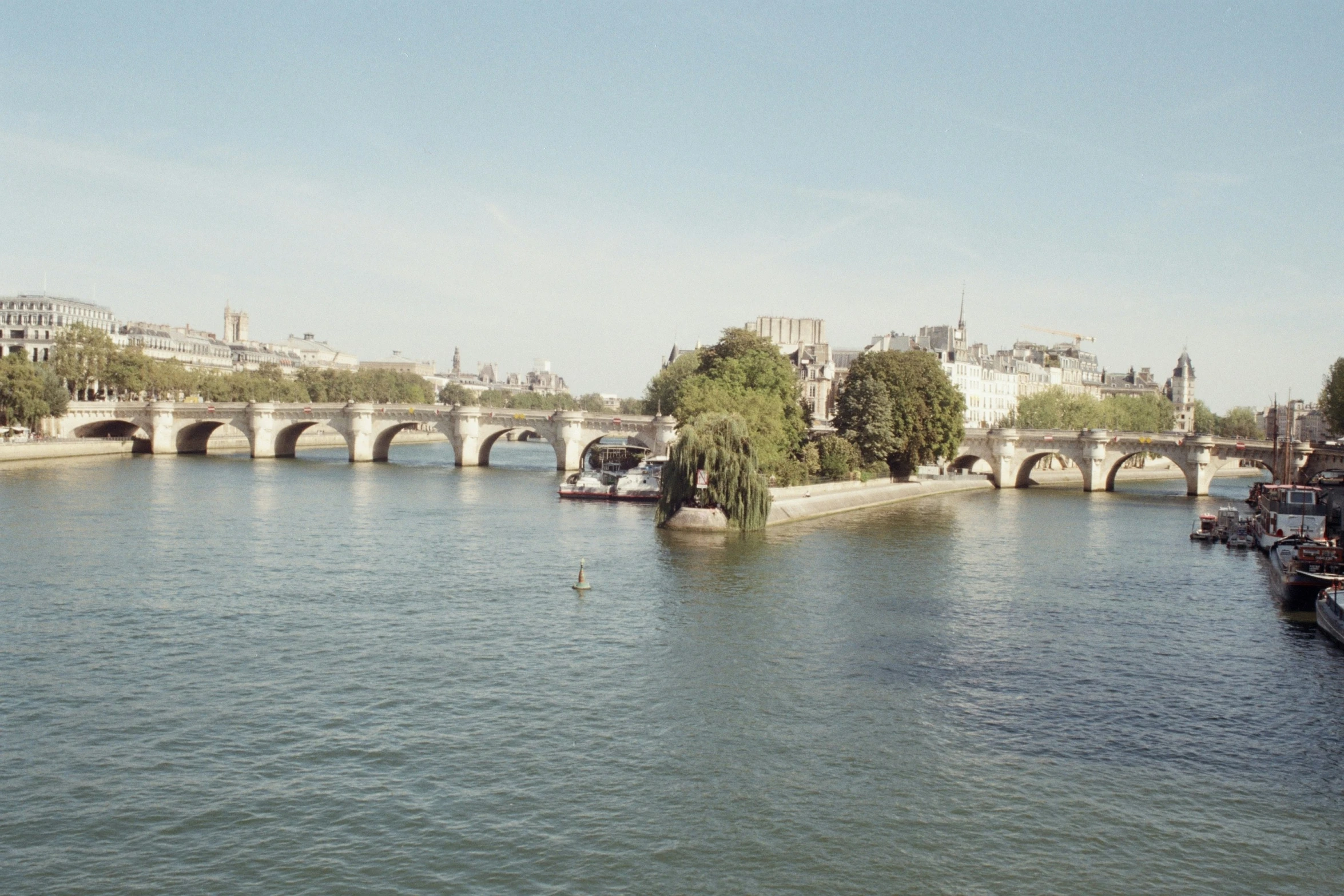 a river and bridge with boats on it