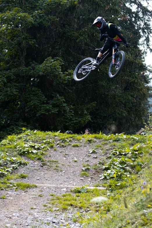 a person on a bike jumping over a dirt path