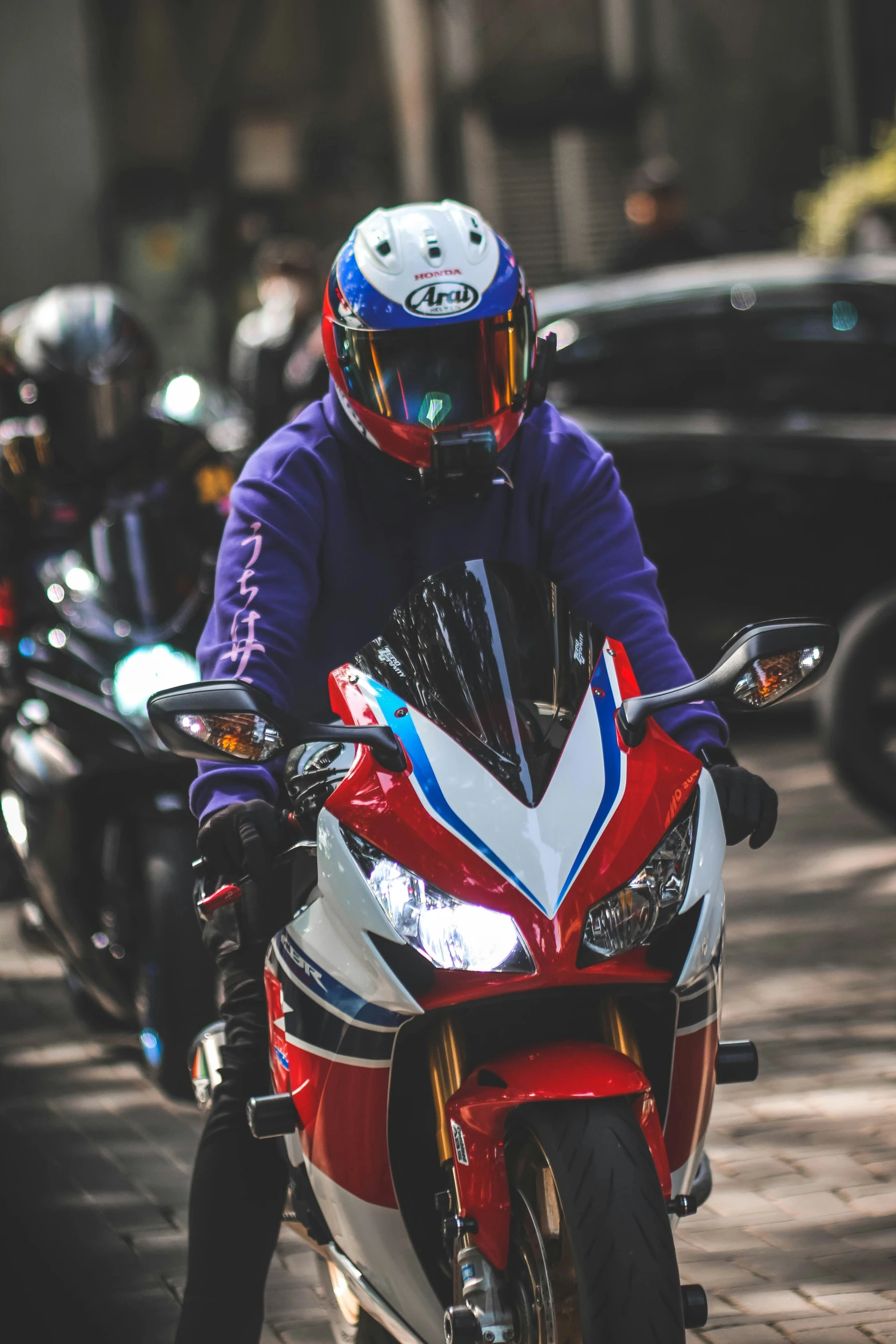 a man on a motorcycle and a group of cars