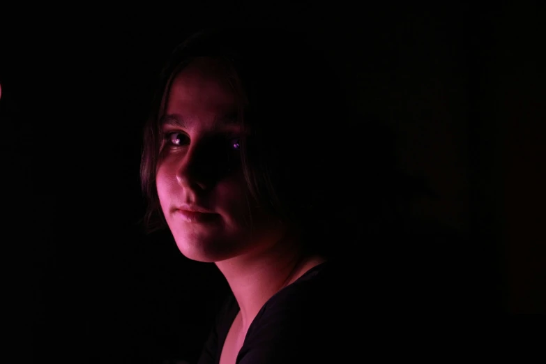 a girl in the dark with an illuminated light