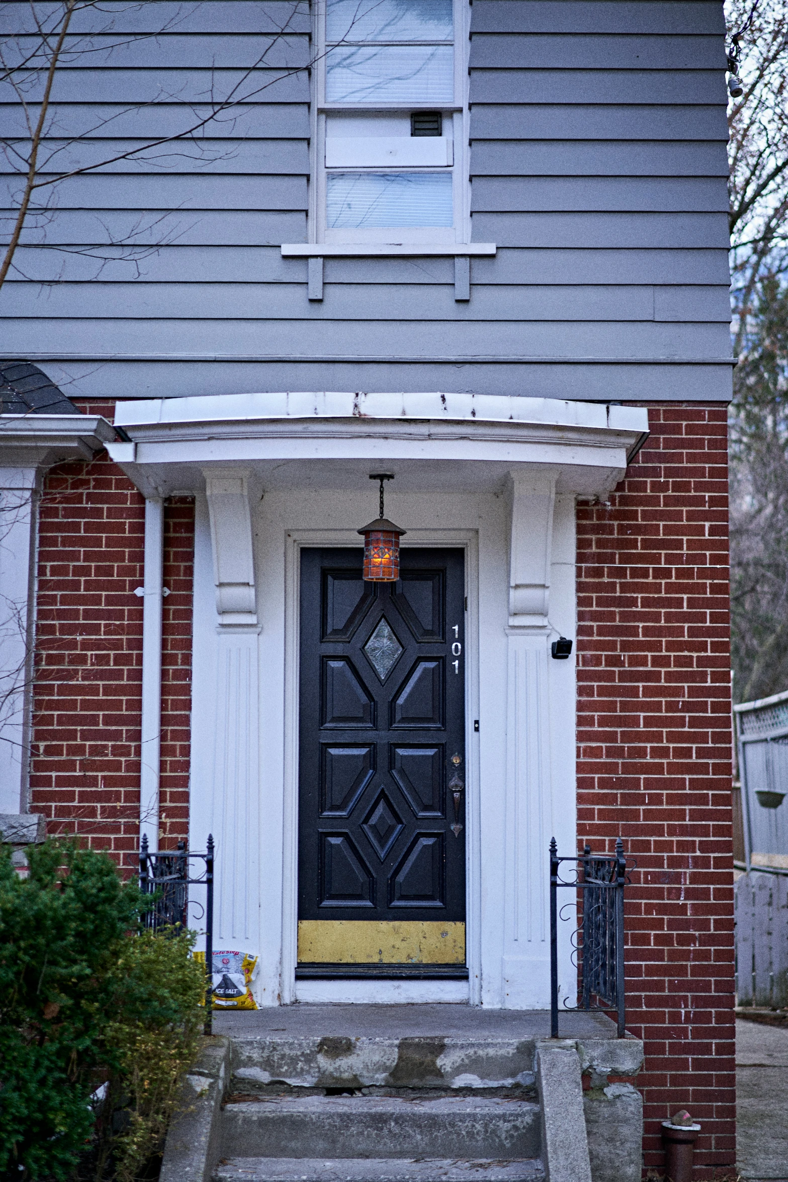 a black door is shown in front of a brick house