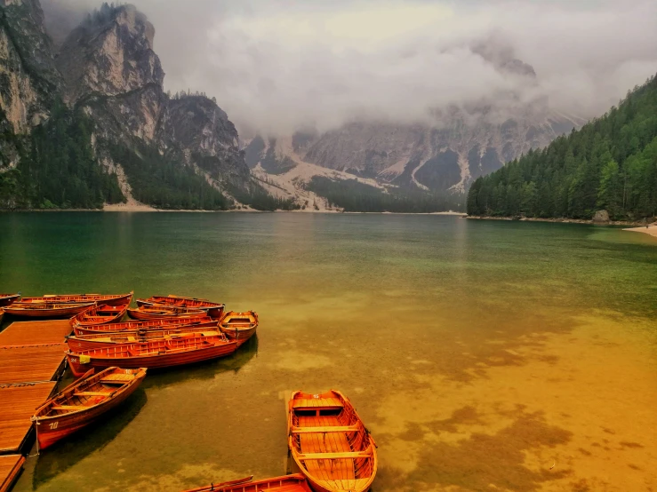 there are several canoes sitting on the waters edge