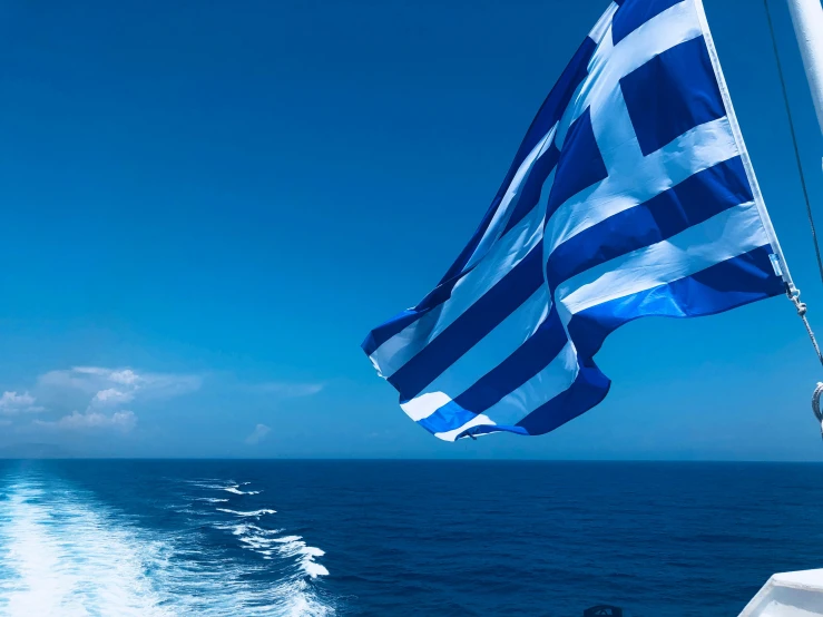 a large blue and white flag flying on top of a boat