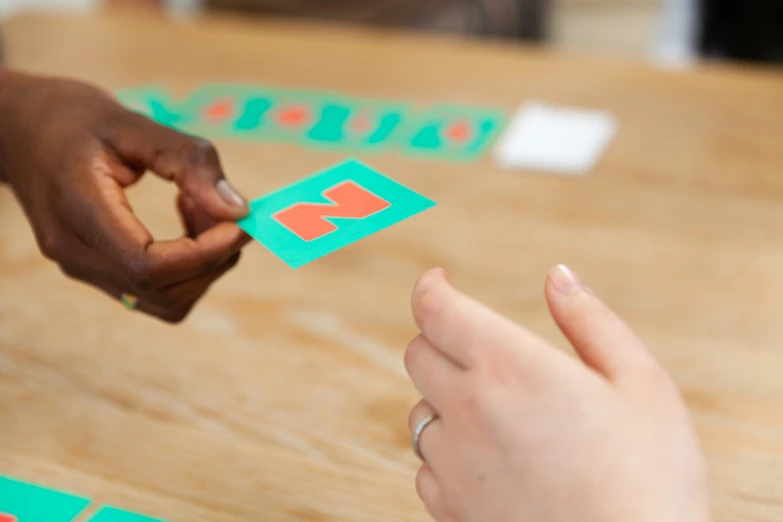 two people playing a game on the wood table