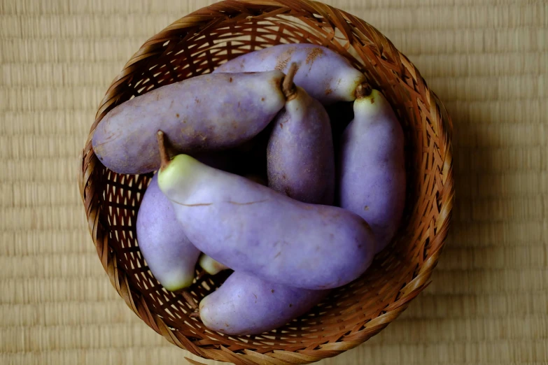purple potatoes in a wicker basket on a wooden surface