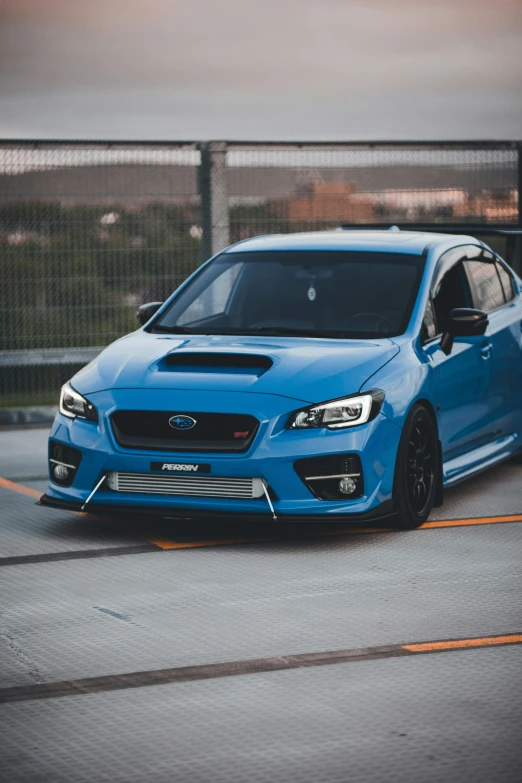 the front of a blue subarunt is driving down the road