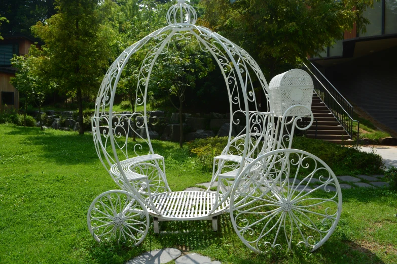 an elaborate metal carriage sits on the lawn
