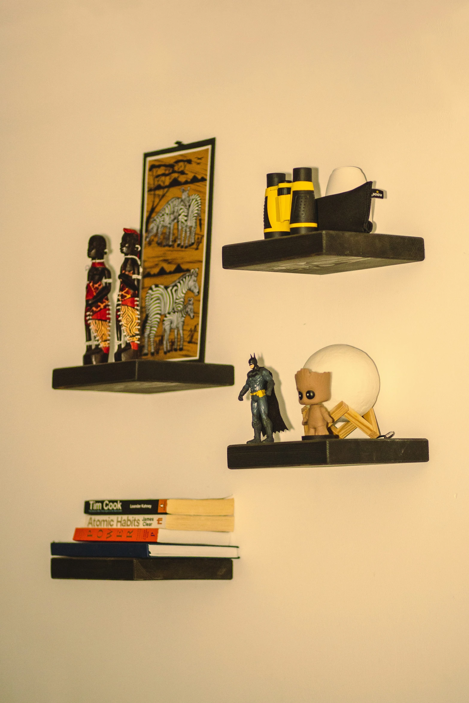 three shelfs with small figurines are on the wall