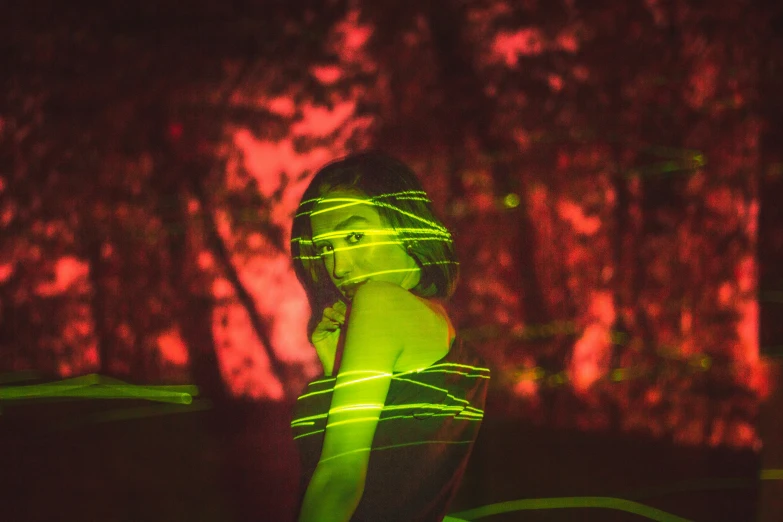 a woman standing in the park with her back to us with a light painting effect