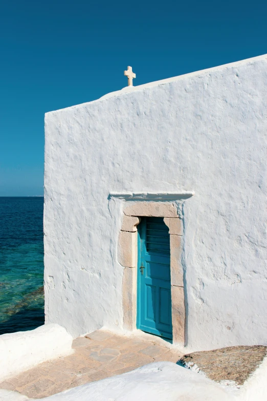 a small church with a big window and a blue door