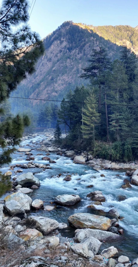 a river surrounded by large rocks next to a forest