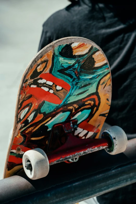 a person holding a skateboard with graffiti on it