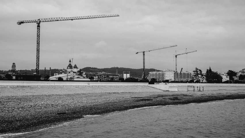 black and white pograph of construction cranes on a cloudy day