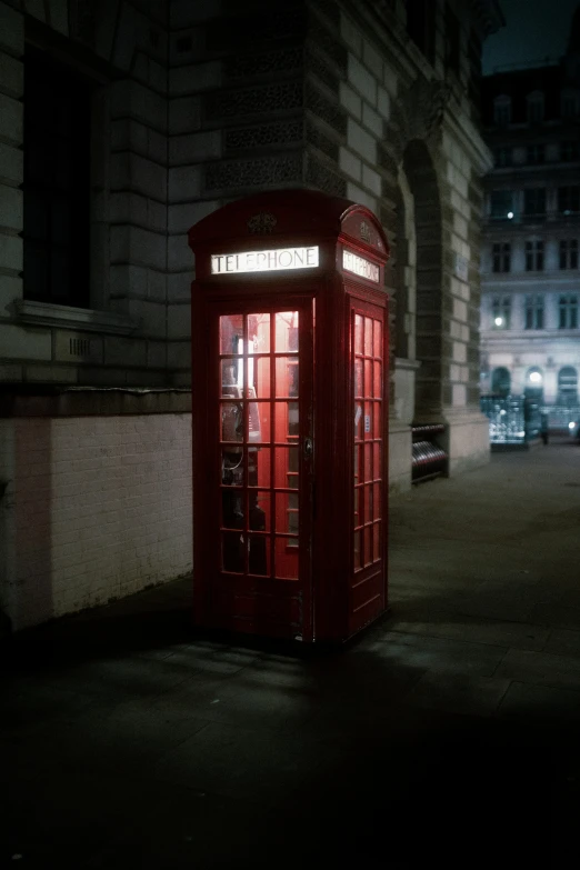 a red telephone booth with lights shining through the window