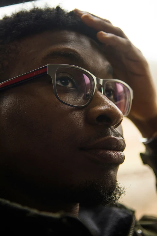 a man with glasses looking down in the dark