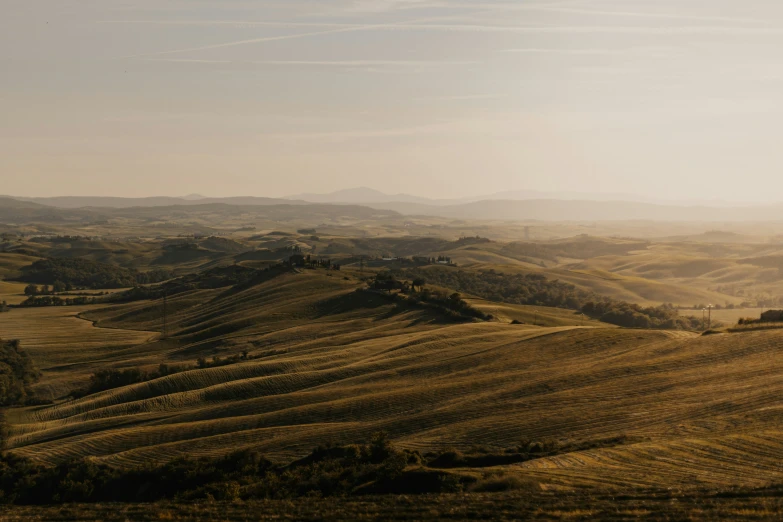 hilly rolling terrain beneath a clear sky and clouds