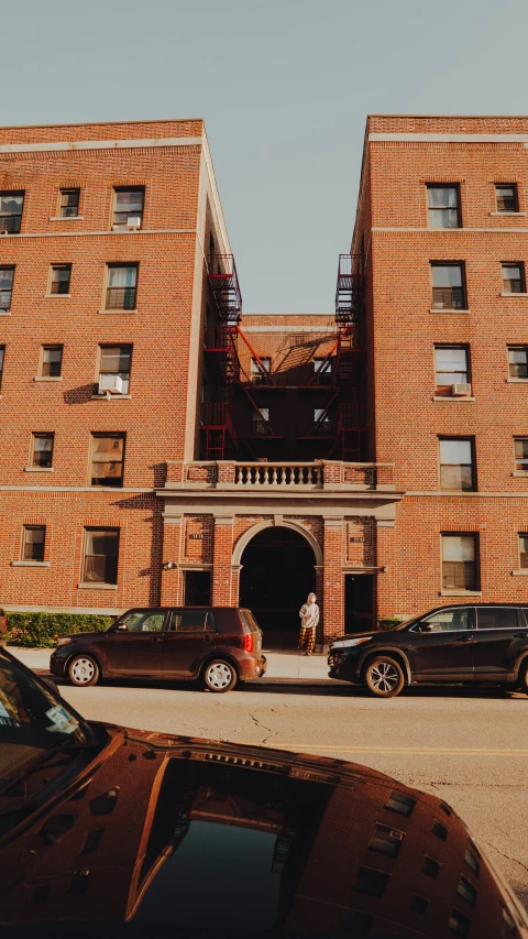 a couple of cars are parked outside of a brick building