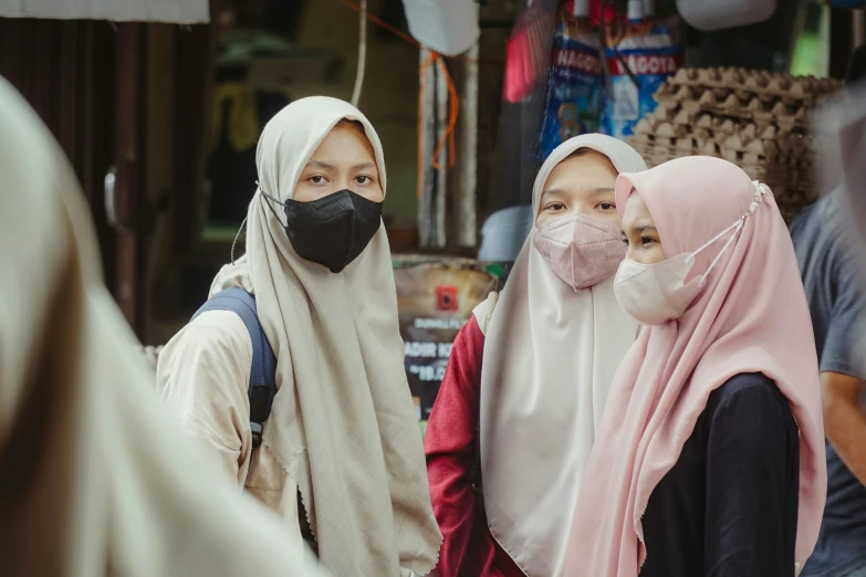 two women in a busy area wear masks for protection