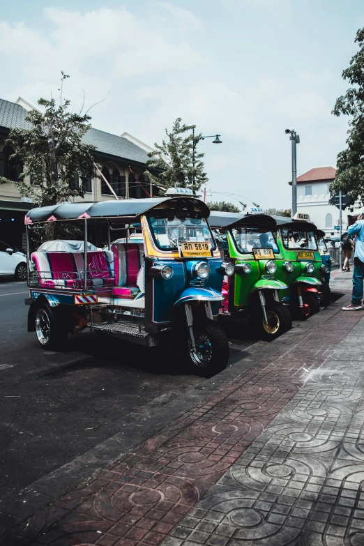 a row of colorful old cars next to each other on a street