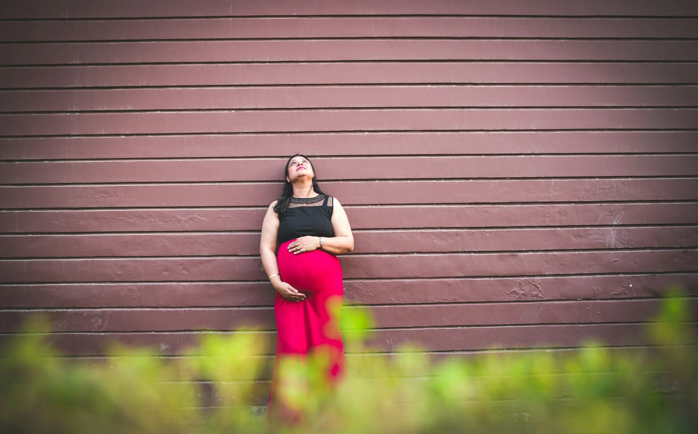 a pregnant woman leaning against the wall