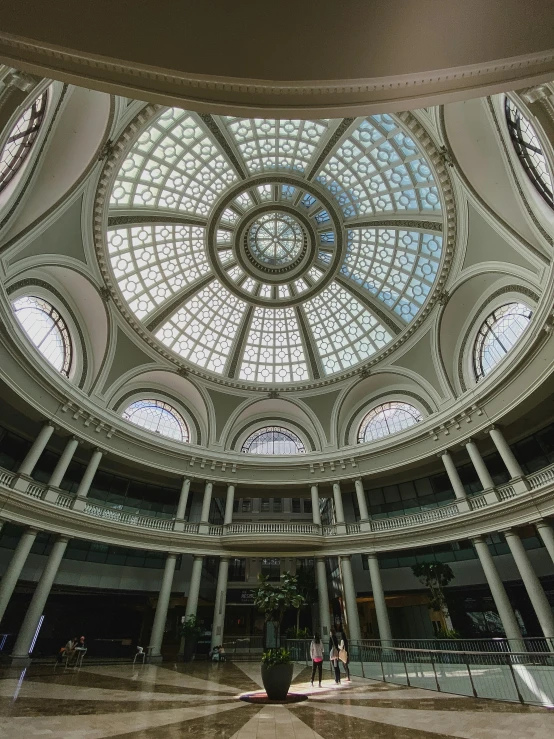 an empty lobby of a building with two tall columns and large glass dome