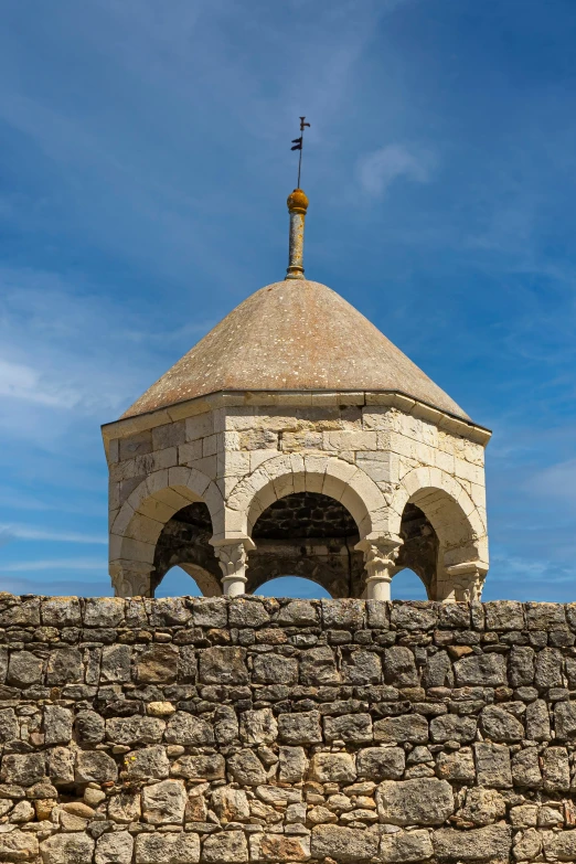 a small stone structure sitting on the side of a brick wall