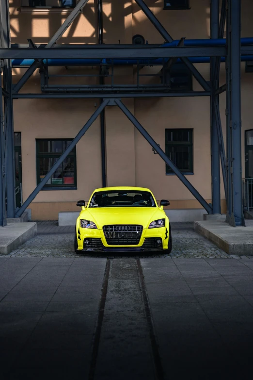 a yellow car that is parked near a building