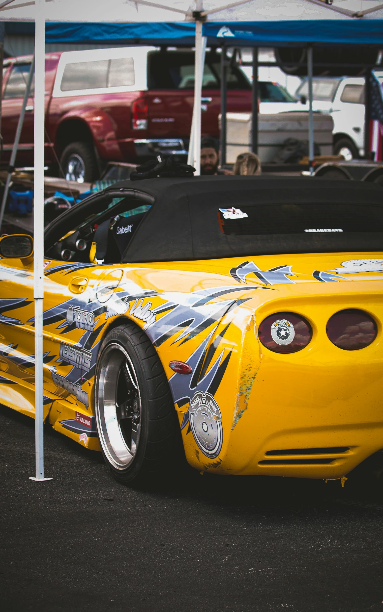 a close up view of a yellow car parked near several other cars