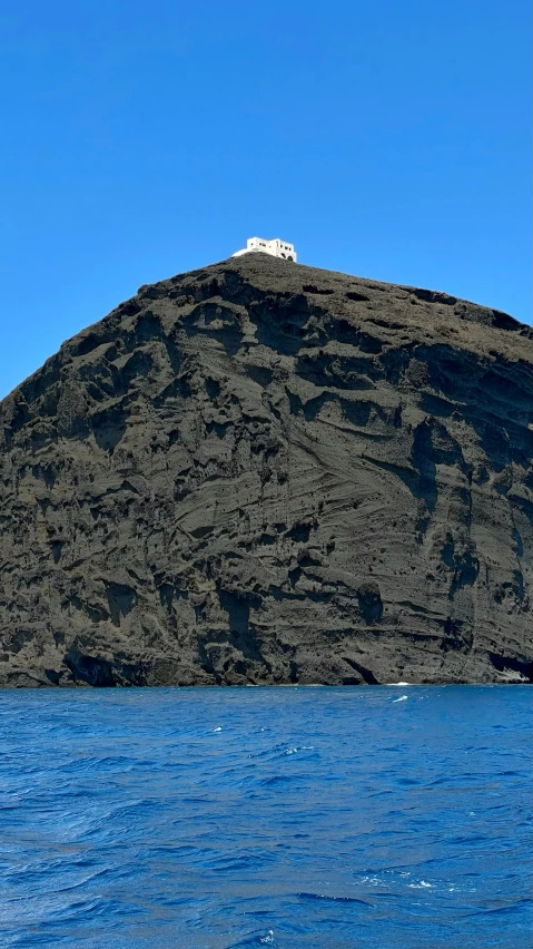 a mountain covered in lots of brown sand near the ocean