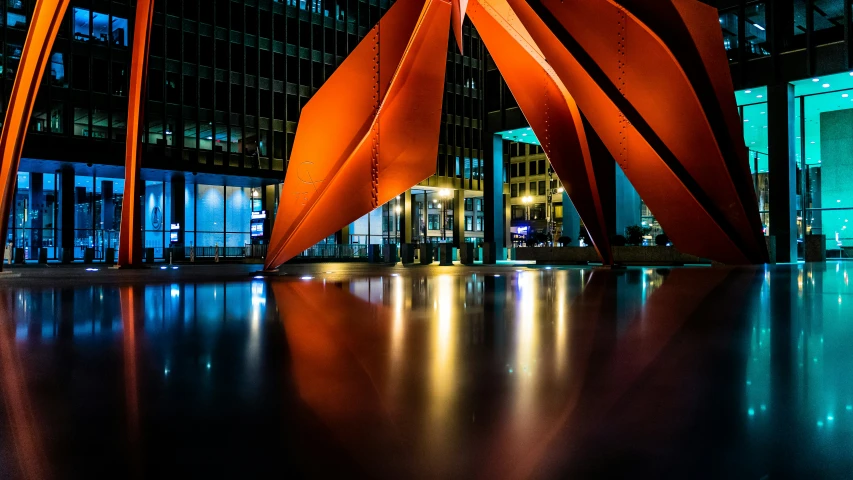 large metal abstract sculpture displayed in front of skyscrs