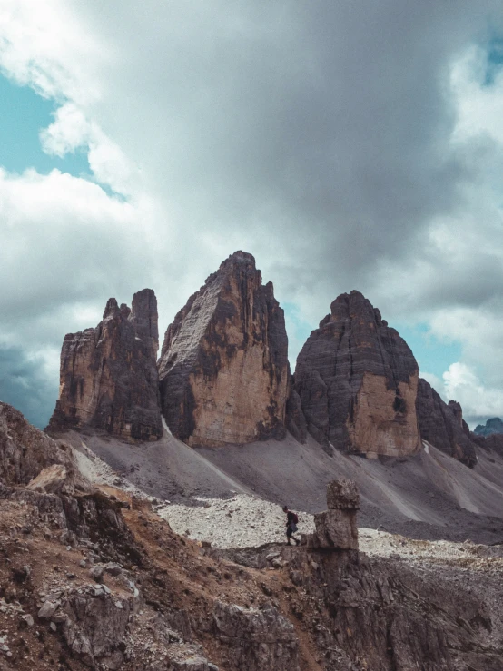 people walking around in front of huge mountains