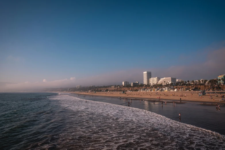 a very long line of people on the beach and in the ocean