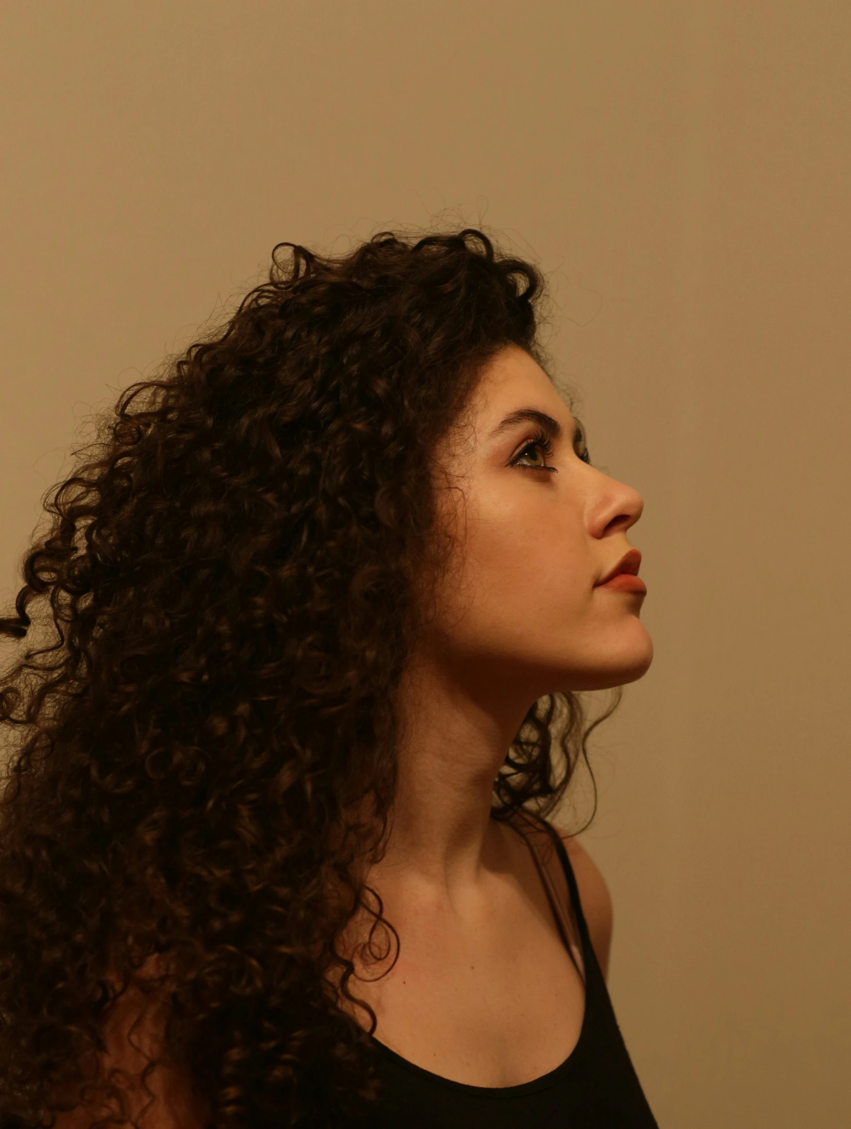 a woman with curly hair looking to the left