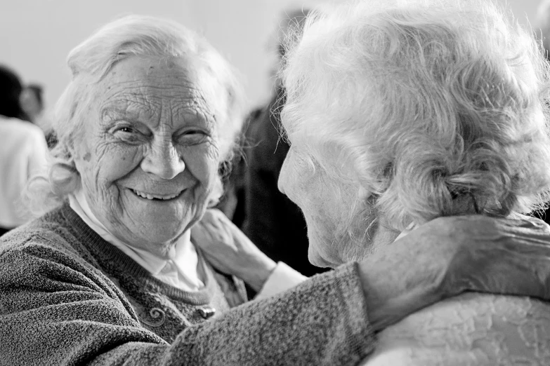 an old couple is hugging together in black and white