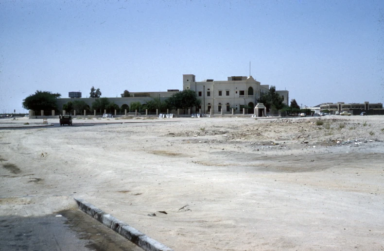 a very big house in the middle of a dirt lot