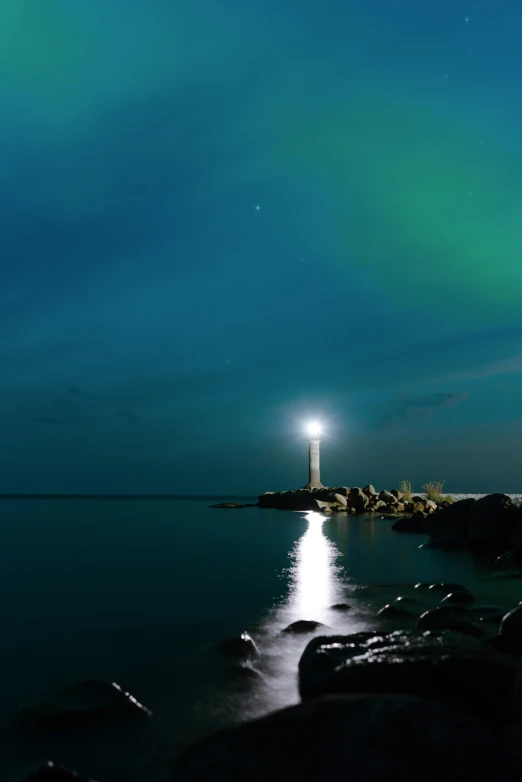 a lighthouse sits out at night under the sky