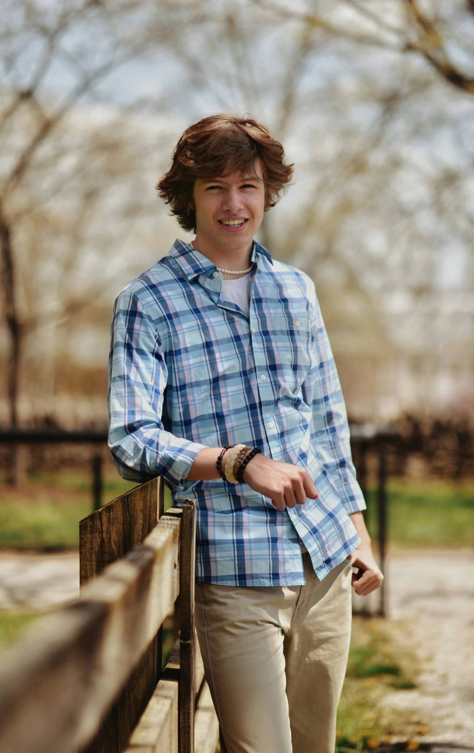 a young man is standing outside with his hands in his pockets