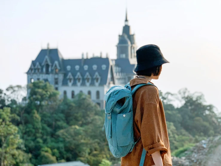 a woman with a backpack looks out over the city