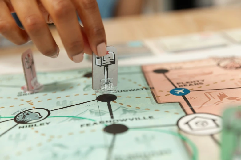 hand of a person playing monopoly with the monopoly board