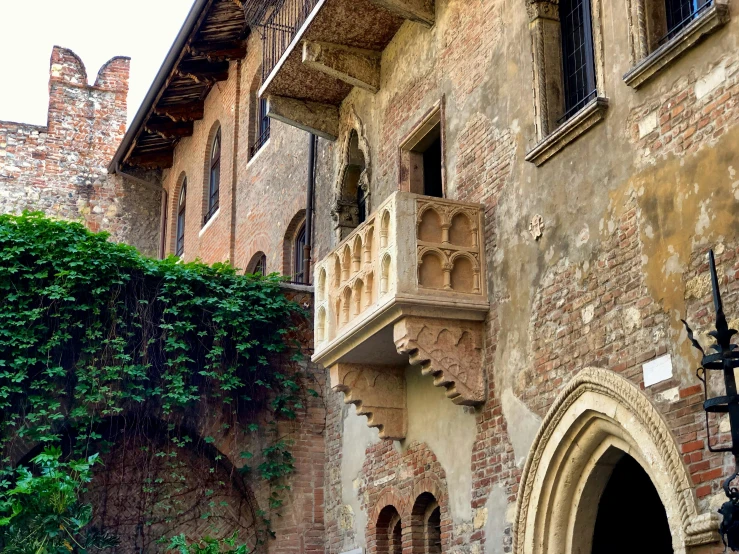 an old building that is made of brick with the arched balconies