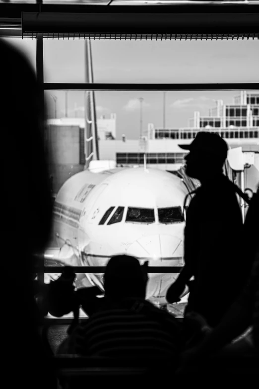 people look out from the window at the planes in the airport