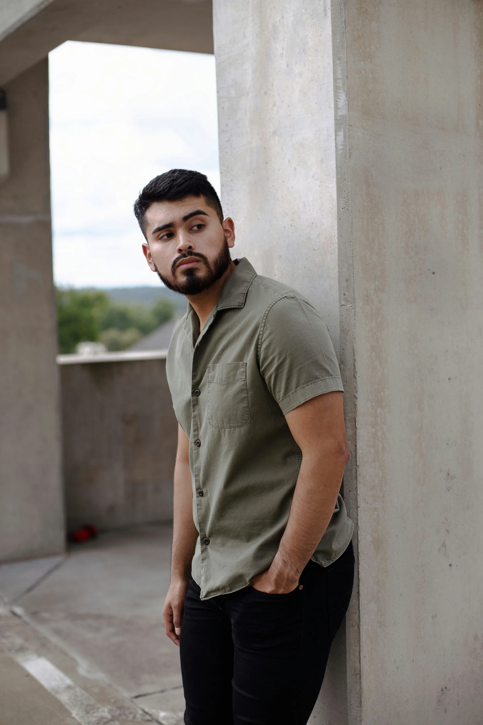 a man leans against the side of a pillar